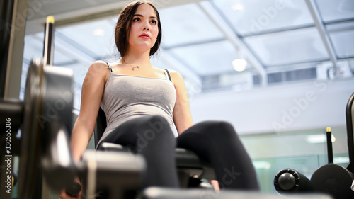 Gym seated leg curl machine exercise woman in the gym