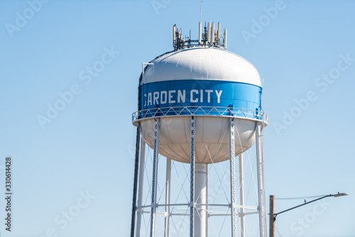 View of water tower sign for Garden City in Kansas countryside industrial town closeup isolated against sky