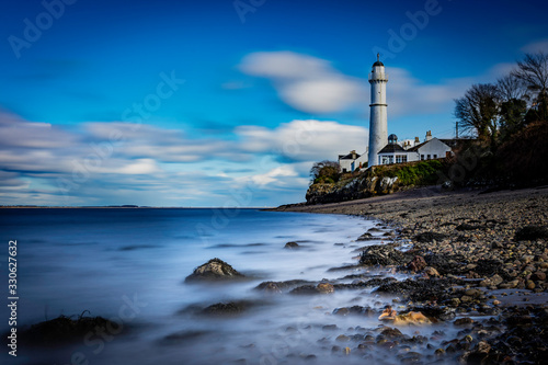 light house at tayport fie scotland with silky water on shoreline.