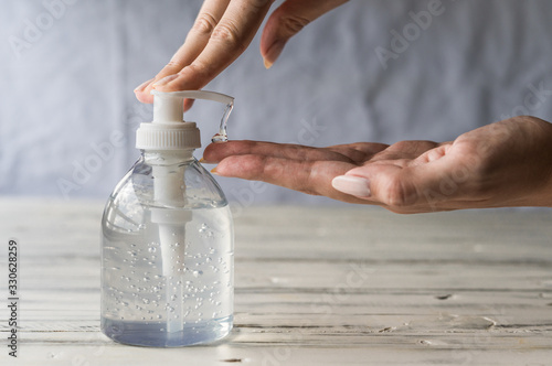 Young woman using hand sanitizer gel with liquid alcohol disinfectant for prevention of coronavirus and other pandemic and epidemic diseases