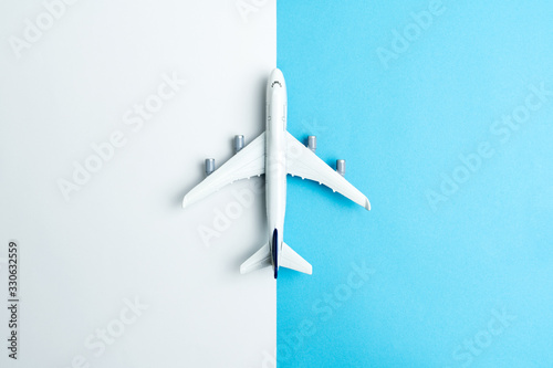 Flat lay miniature airplane model isolated on white and blue background