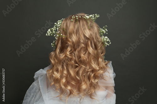Beautiful female back with long blonde curly hair. Perfect wedding hairdo