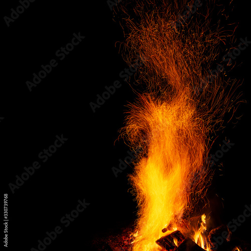Campfire with sparks on a black background with a copy space