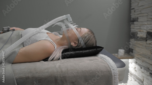 Girl lies on bed with artificial respiration mask