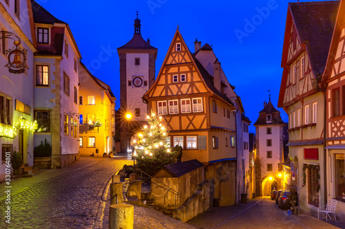 Decorated and illuminated Christmas street with gate and tower Plonlein in medieval Old Town of Rothenburg ob der Tauber, Bavaria, southern Germany