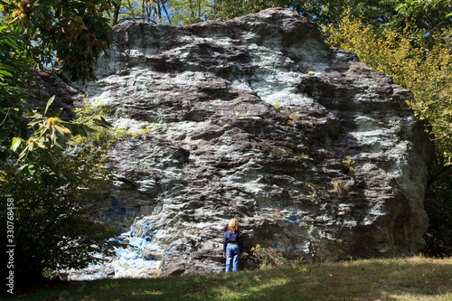 Sesto Calende (VA), Italy - September 15, 2016: A tourist near the gigantic stone named Sass da Preja Buia, San vincenzo, Sesto Calende, Varese, Lombardy, Italy.