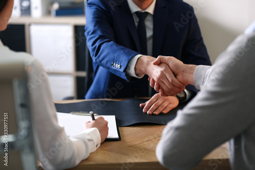 Male lawyer working with clients in office, closeup