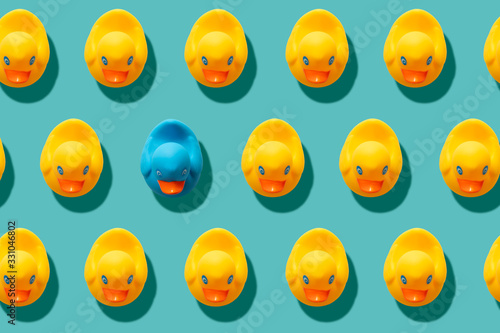 yellow rubber ducks on turquoise blue background one duck different