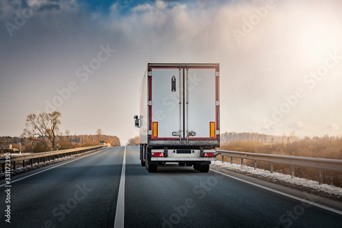 Lorry truck on the highway from behind during sunset