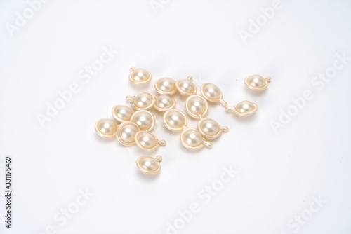 Fragrant beads in the shape of silvery water droplets on a white background