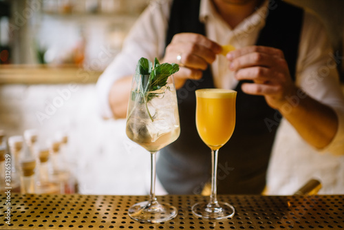 barmen preparing mint spritz and orange sour cocktails