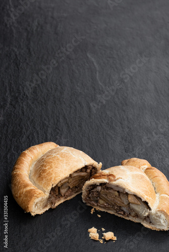 Homemade cornish pasty on black stone background