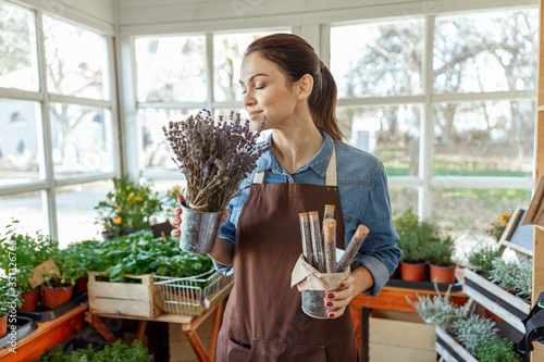 Serene horticulturist with wild flowers standing indoors