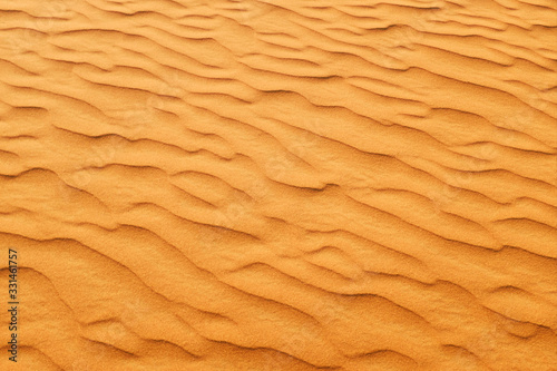 Rich orange color desert sand wave patterns for a warm summer background.