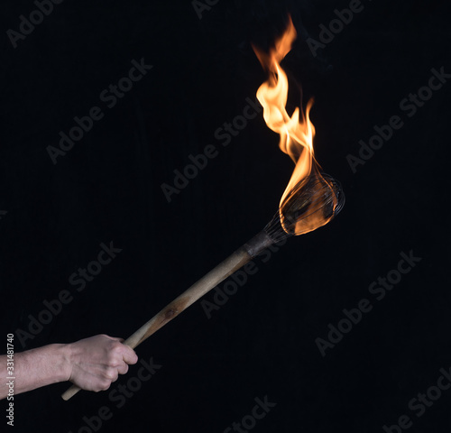 wooden burning torch on a black background