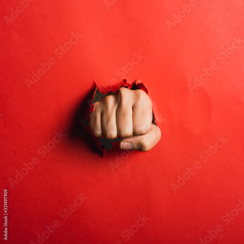 Human hand tearing red paper with the word coronavirus, concept in the fight against coronavirus