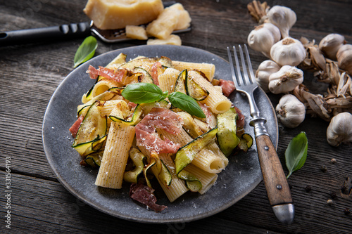 Tasty rigatoni pasta with courgette, prosciutto ham and grana padano cheese