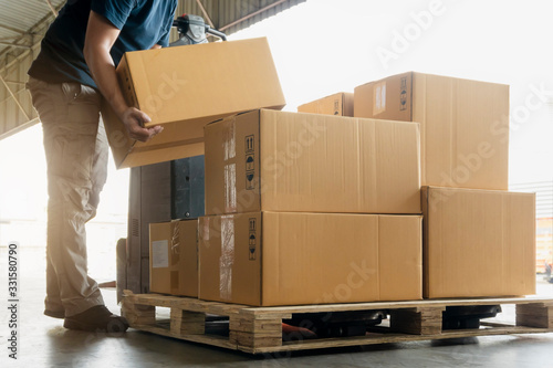 Worker courier lifting packaging boxes stacking on pallet. warehouse delivery service shipment goods supply chain