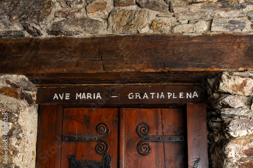 Text from the Catholic prayer to the virgin Mary "ave maria gratia plena" above the door of the old Church.