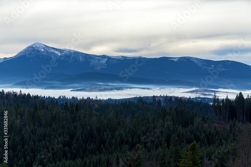 An image of white clouds over beautiful mountains