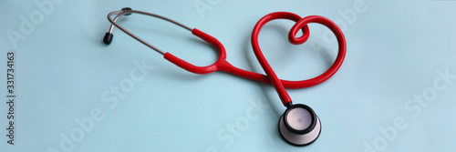 Red stethoscope with heart on blue modern background. Medical insurance concept