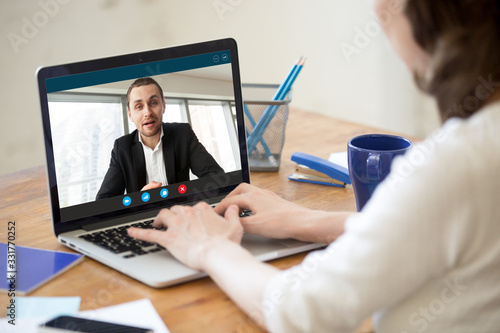 View over shoulder female employer listen applicant at distant job interview using webcamera and pc. Modern tech helps communicate during corona virus covid19 ncov infection outbreak, webinar concept