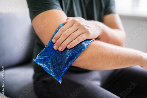 Man Using Ice Gel Pack On Arm