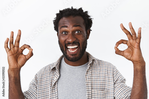 Close-up shot handsome excited, amused bearded african-american man, approve something good, showing okay or ok sign in approval or agree, smiling enthusiastic and delighted, white background