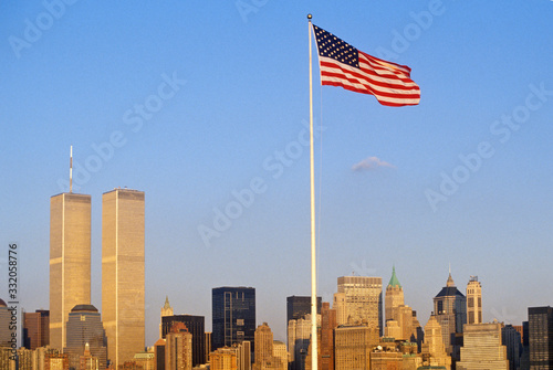 American Flag flying over skyline of New York City from New York Harbor, NY