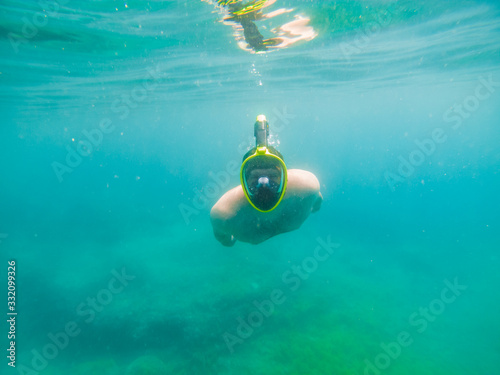 man swimming underwater with snorkeling musk