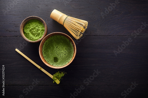 Matcha powder. Organic green matcha tea ceremony. Healthy drink. Traditional japanese drink on black wooden background