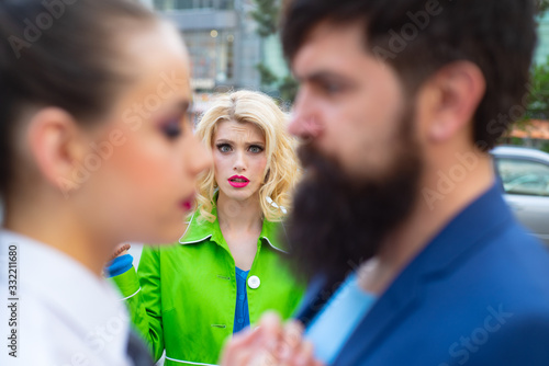 Cheating in marriage. Man looking other woman. Terribly jealous of them. Jealous woman look at couple in love on street. Unhappy girl feeling jealous.