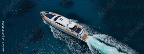 Aerial drone top down photo of luxury yacht with wooden deck anchored in open ocean sea