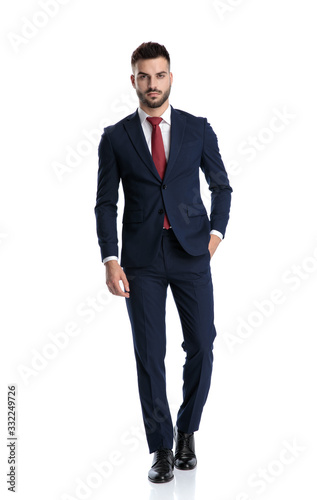 businessman walking with hand in pocket and striking a pose