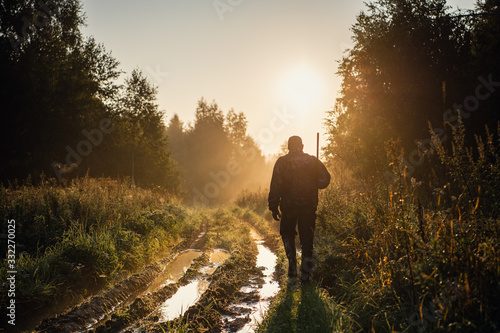 Silhouetted of a hunter with shotgun at beautiful sunset