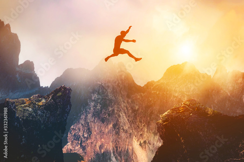 Man jumping between rocks. Overcome a problem for a better future