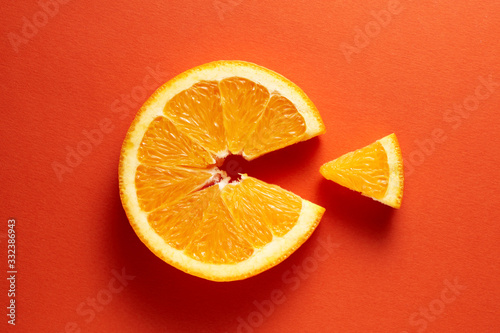 Orange slice symbolizing vitamin c is eating the cut out piece on orange background