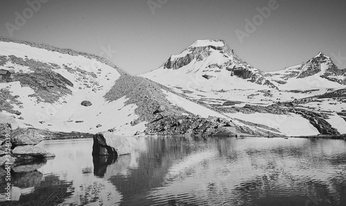 Gran paradiso big stone in a mountain lake black and white 