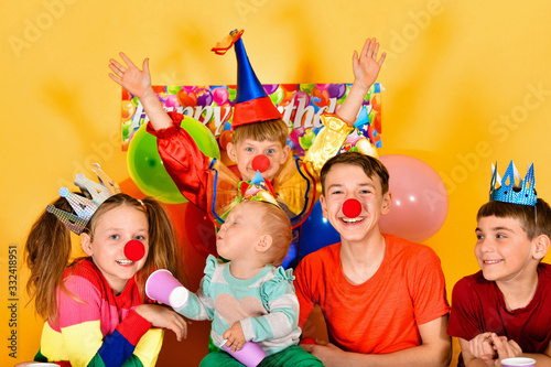 Clown child and joyful children at a festive event.