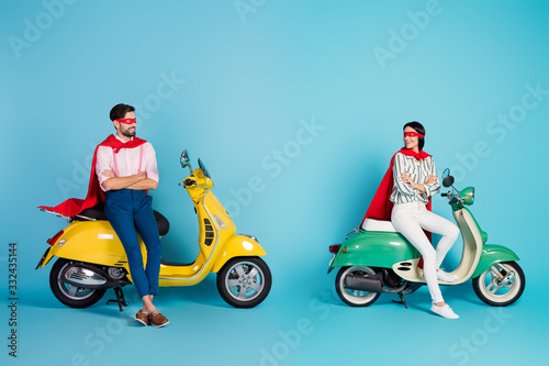 Full body photo of funny cool lady guy arms crossed sit two vintage moped wear red cape mask ready for halloween party play super heroes role isolated blue color background