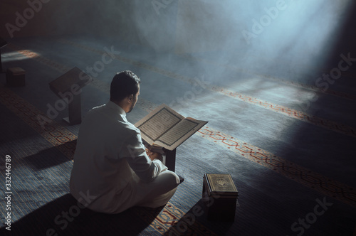 Young Muslim Guy Reading The Koran