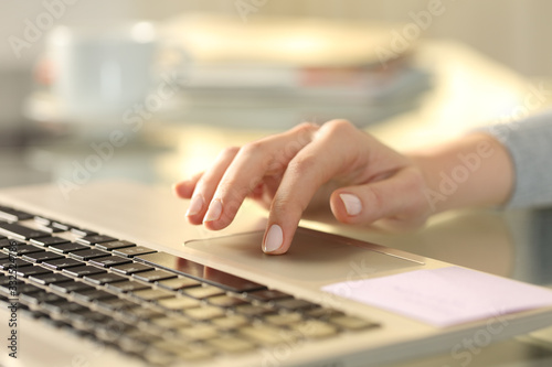 Woman hand with laptop using touchpad on a desk