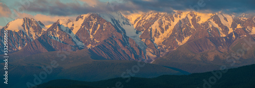 Mountain landscape, panoramic view. Pink light of dawn on the mountain tops.