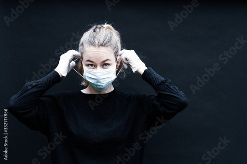 une jeune femme blonde se place un masque de protection sur le visage