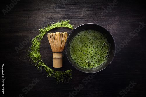 Matcha powder. Organic green matcha tea ceremony. Healthy drink. Traditional japanese drink on black wooden background