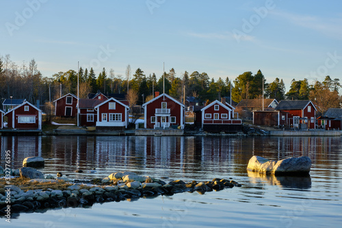 Small red houses by the sea with stones in the foreground