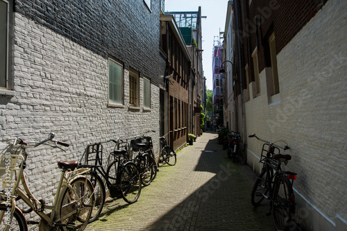 Bicycle parking on narrow street. Empty courtyard. Dutch architecture.