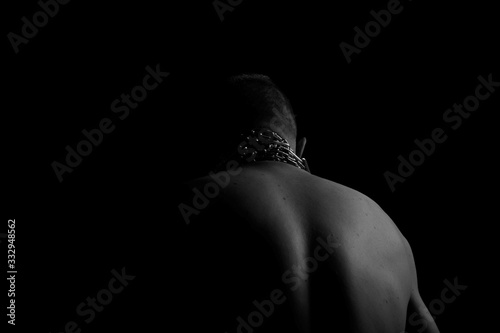 Back. The back of the man. Man holding a chain on his back in both hands. Chain. Black and white photo. Power. Sports Hall.