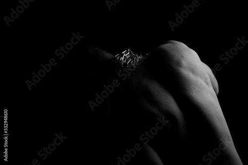 Back. The back of the man. Man holding a chain on his back in both hands. Chain. Black and white photo. Power. Sports Hall.