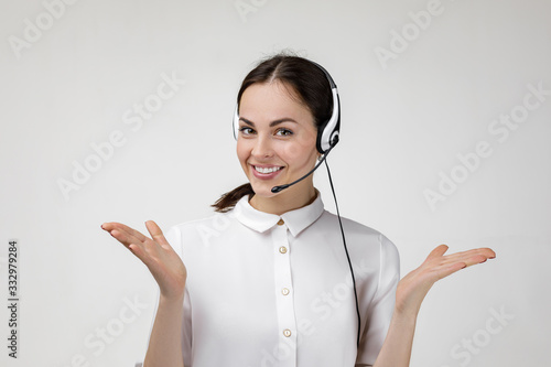 Beautiful smiling woman consultant of call center in headphones on gray background. female customer support operator with headset